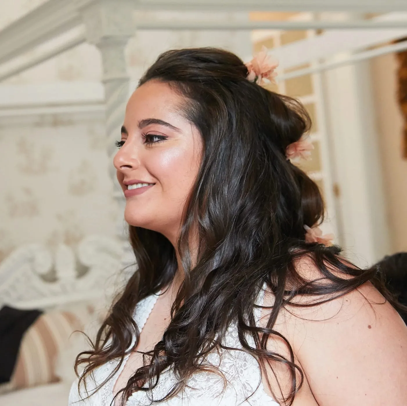 Novia preparada para su boda con maquillaje natural en tonos rosados y semirecogido con flores